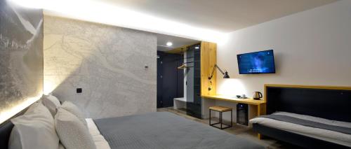 马里博尔Hotel CityMap Maribor的酒店客房,配有床和沙发