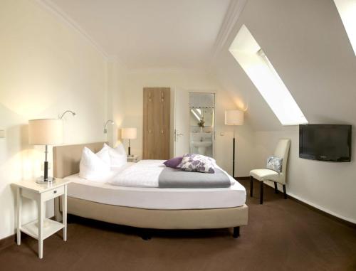 黑灵斯多夫尼普顿酒店的一间带大床和电视的卧室
