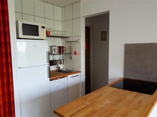 塞尼奥斯Réf 541,Seignosse Océan, Appartement 3 pièces, proche de la plage et des commerces, 4 personnes的厨房配有白色冰箱和微波炉