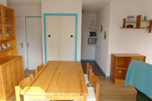 塞尼奥斯Réf 546, Seignosse océan , Appartement classé 2 étoiles , plage et centre à 5mn, 5 personnes的一间用餐室,在房间内配有木桌