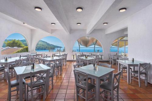 帕诺尔莫斯斯科派洛斯阿德里纳海滩酒店的一间带桌椅的海景餐厅