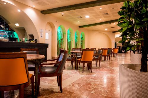 埃拉特Club In Eilat Resort - Executive Deluxe Villa With Jacuzzi, Terrace & Parking的餐厅设有桌椅和绿色窗户。
