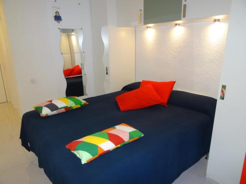 阿德耶Ocean View的一间卧室配有蓝色的床和色彩缤纷的枕头