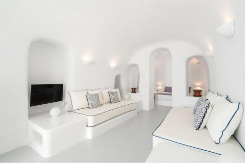 伊亚Oia Spirit Boutique Residences的白色的客厅配有2张白色沙发和电视