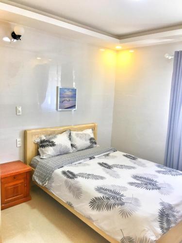 大叻晃武旅馆的一间卧室配有一张床和一张木桌