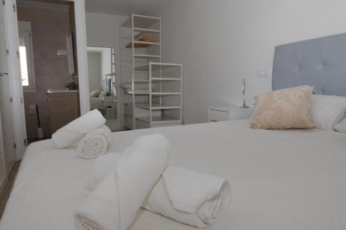 马德里Moderno,tranquilo, entrada autónoma y fácil aparcamiento.的卧室配有白色床和毛巾
