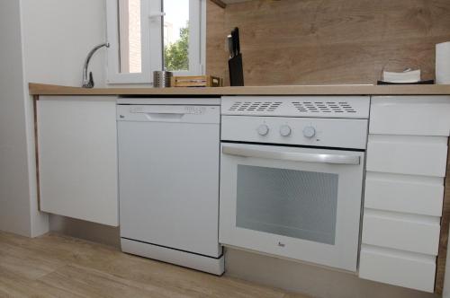 马德里Moderno,tranquilo, entrada autónoma y fácil aparcamiento.的厨房配有白色炉灶和水槽
