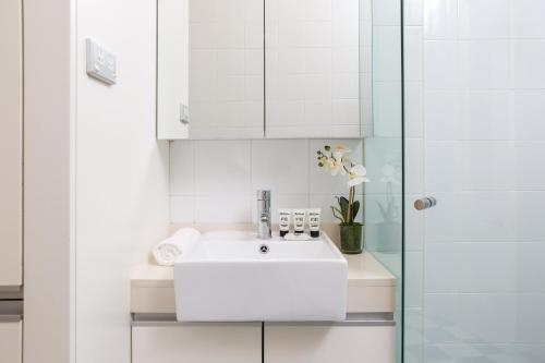 悉尼Ravenscourt’s Studio Apartment Close to Everything的白色的浴室设有水槽和淋浴。