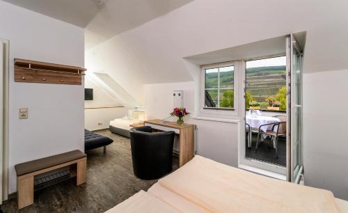 莱茵河畔的宾根克朗酒店的一间带一张床的房间和一间带桌子的用餐室