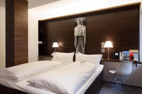 科隆斯特恩市政厅酒店的卧室配有两张床,墙上设有雕像