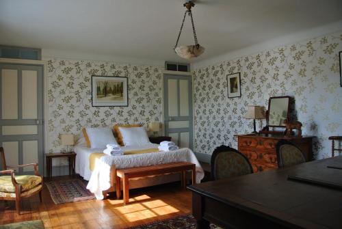 乌瑞基尼Erlande Baïta的卧室配有一张床和一张桌子及椅子