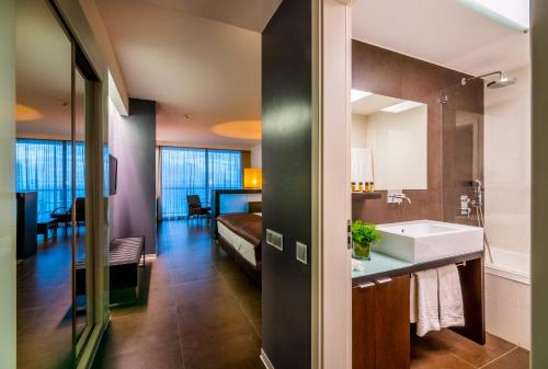 波尔蒂芒RR Hotel da Rocha的一间带水槽的浴室和一张位于客房内的床