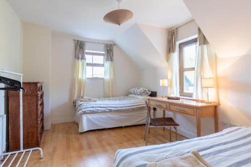 斯尼姆Álaind Lodges, Sneem的一间卧室设有两张床、一张桌子和一个窗口。
