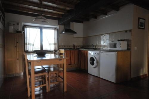 韦加港Apartamentos Rurales Romallande的厨房配有桌子和洗衣机。