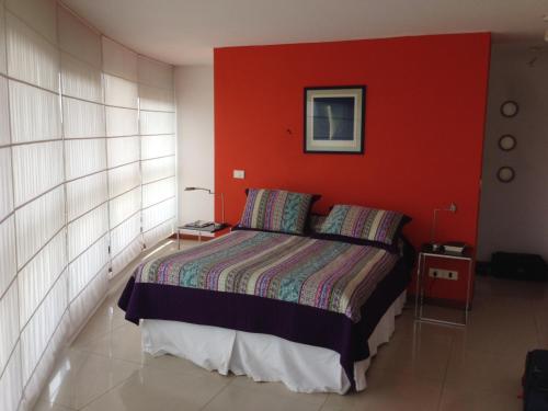埃斯特角城Apartamento 907的一间卧室配有一张红色墙壁的床