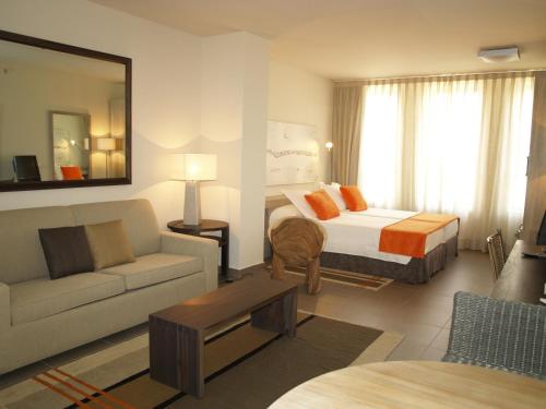 马德里阿尔卡拉套房生态酒店的酒店客房,配有床和沙发