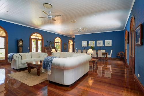 拜伦湾伊文思山谷维多利亚酒店的客厅设有白色沙发和蓝色的墙壁。