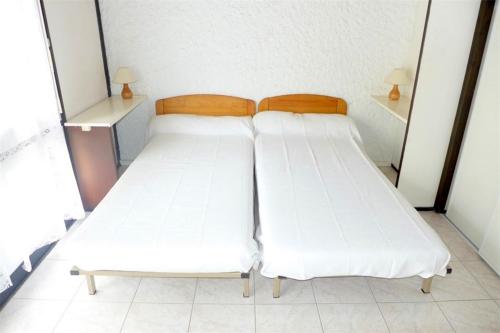 塞尼奥斯Réf 200, Seignosse Océan, Villa Patio au calme, à 2 pas de la plage des Bourdaines的配有白色床单的客房内的两张床