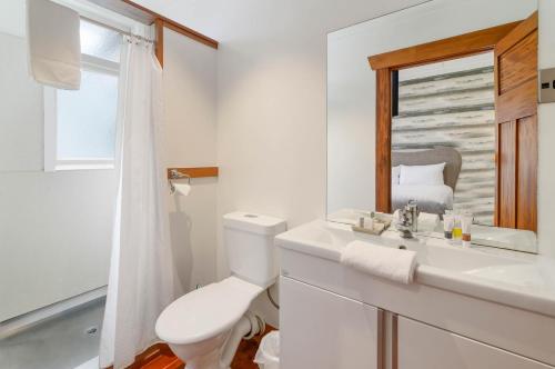 罗托鲁瓦Lakes Lodge Rotorua的一间带卫生间、水槽和镜子的浴室