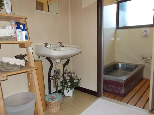 鸣泽市堆栈指针旅舍的浴室配有盥洗盆和浴缸。