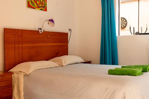 库斯科House in Cusco的一间卧室配有一张带木制床头板的床和窗户。