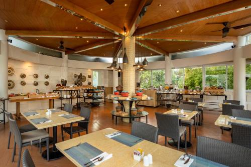 勒吉安Away Bali Legian Camakila Resort的一间带桌椅的用餐室和一间餐厅