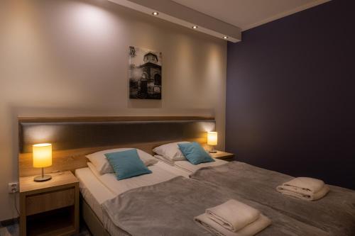 巴尔多巴尔多酒店的一间卧室配有两张带蓝色枕头的床