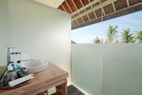 乌鲁瓦图克让宾海滩别墅的一间带水槽和玻璃淋浴的浴室