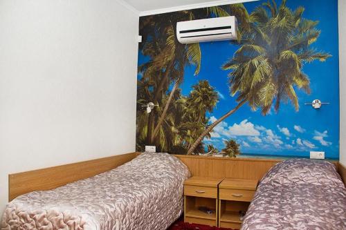 斯塔夫罗波尔帕利提亚旅馆的一间设有两张床和棕榈树壁画的房间