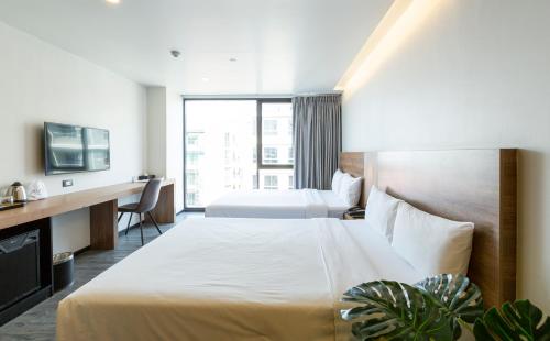 曼谷STAY Hotel BKK - SHA PLUS的酒店客房设有两张床和电视。