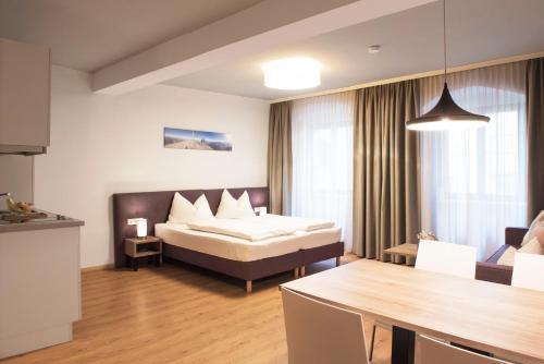 因斯布鲁克Daxburg Apartments的酒店客房配有一张床铺和一张桌子。