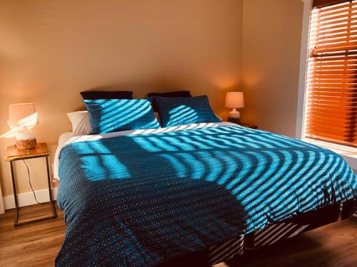 伦弗鲁港Botany Bay by Eagle Reach Properties的卧室里一张蓝色和白色的床,卧室里设有窗户