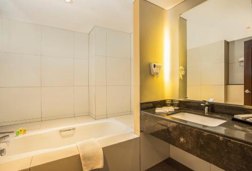 茂物Swiss-Belhotel Bogor的带浴缸、水槽和镜子的浴室