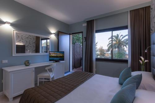 费拉约港Hotel Airone isola d'Elba的一间卧室配有一张床和一张带电脑的书桌
