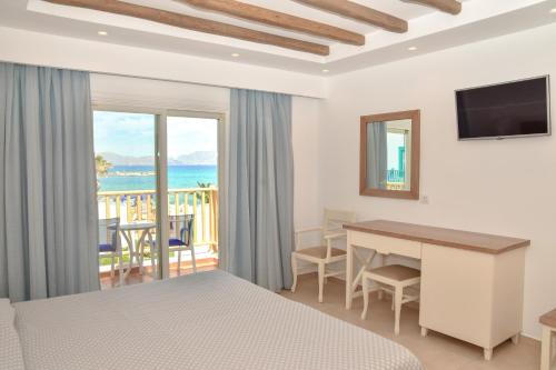 马斯蒂查里马斯特查伊湾大酒店的一间带一张床和一张书桌的卧室以及一个阳台