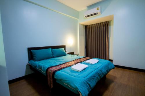 程逸府จุฑาแมนชั่น的一间卧室配有蓝色的床和2条毛巾