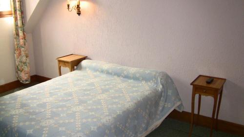 Jouy-le-Potier奥博格戴斯波迪尔斯酒店的一间小卧室,配有一张床和两张桌子