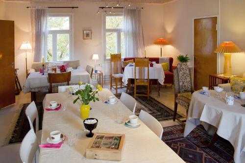 萨翁林纳罗西兰塔旅舍的一间设有白色桌椅的用餐室