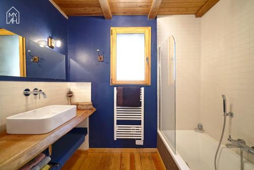 TassoLes gites de Tasso的一间带水槽和浴缸的浴室以及窗户。
