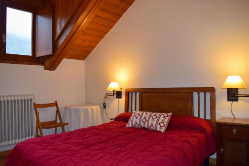 贝纳斯克Duplex con vistas en Benasque的一间卧室配有一张红色床罩的床