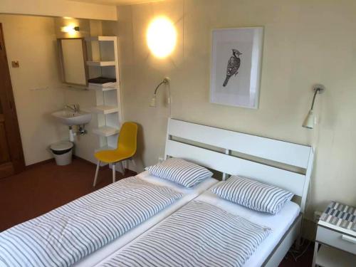 什平德莱鲁夫姆林罗莫卡酒店的卧室配有白色的床和黄色椅子