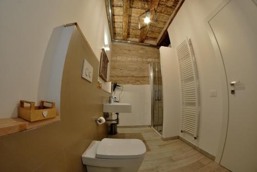 洛雷托B&B DEL CORSO的一间带白色卫生间和木制天花板的浴室