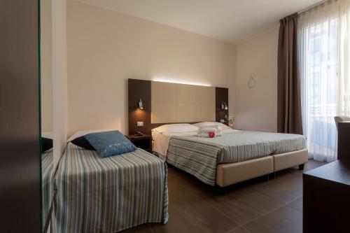 里米尼格米酒店的酒店客房设有两张床和窗户。