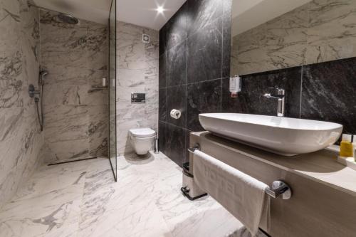 贝拉内Hotel Berane的一间带水槽、淋浴和卫生间的浴室