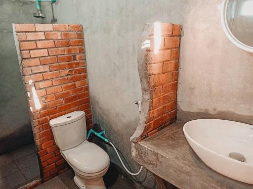 高兰Ozone Beach Huts的浴室设有砖墙、卫生间和水槽。