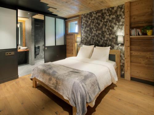 Le Petit-Bornand-lès-GlièresChalet 1703 - Open Living Hotel & Spa的一间带大床的卧室和一间浴室