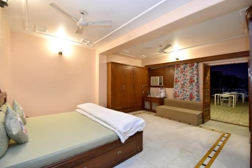 斋浦尔斋浦尔粉红色大象旅馆的一间卧室配有一张床,窗户配有桌子