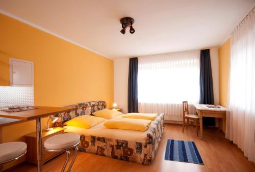 雷根斯堡Hotel Hottentotten的一间卧室配有一张床、一张书桌和一个窗户。