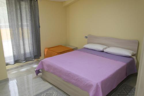 维博瓦伦蒂亚Stella d'Oro的一间卧室设有紫色的床和窗户