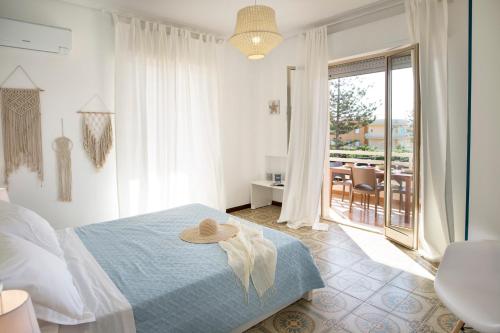 拉古萨码头siciliacasevacanze - Marina Domus 82的一间卧室,配有一张床,上面有帽子